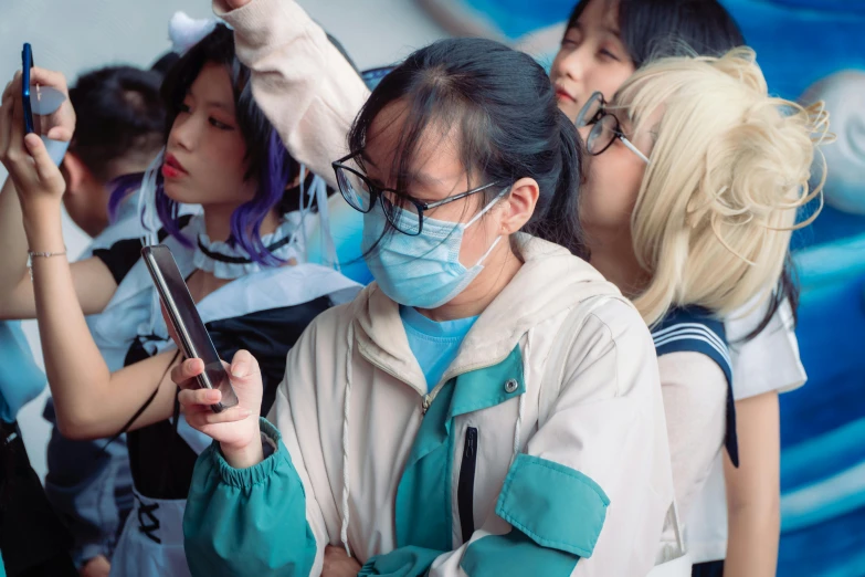 an asian woman holding up a cell phone