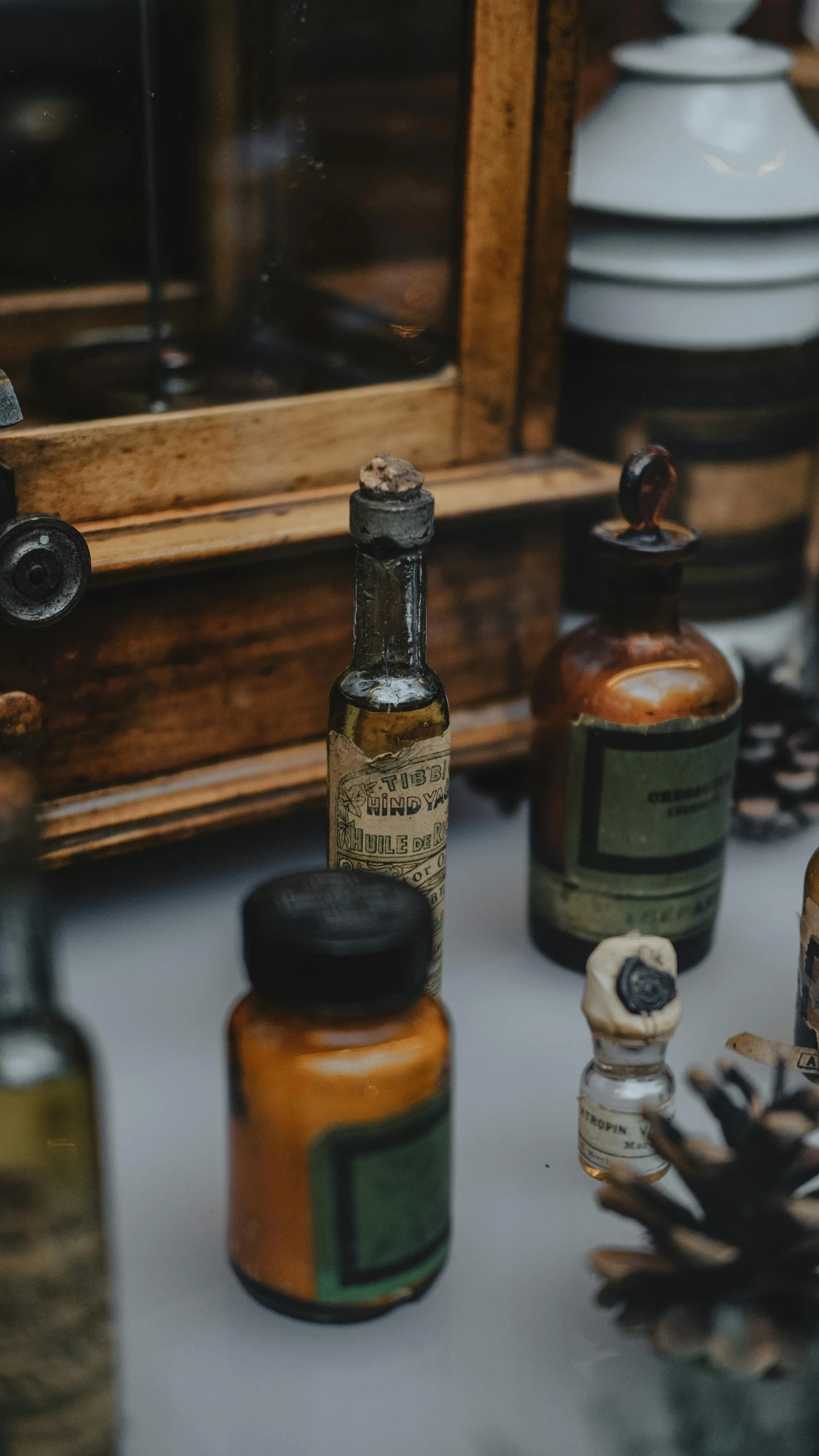 small containers holding bottles are arranged near an antique mirror