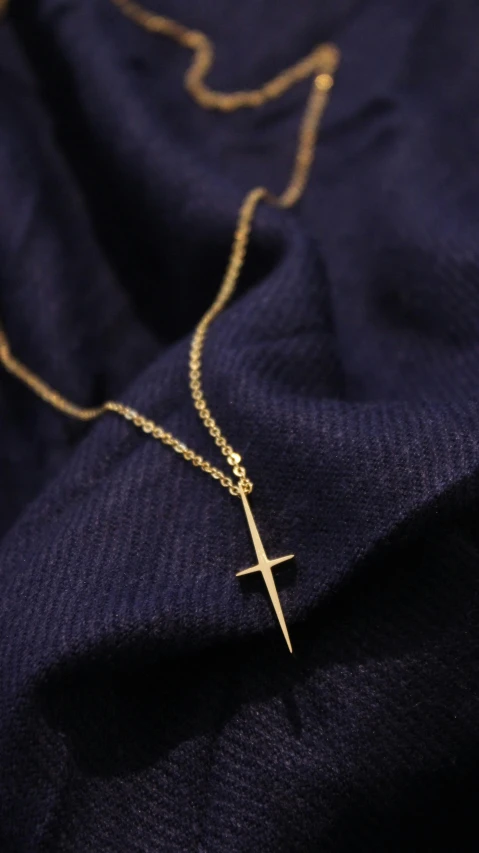 a cross with a chain on it laying on a blue cloth