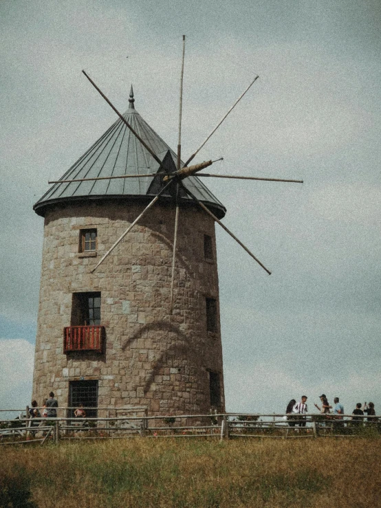 a windmill with people walking around behind it