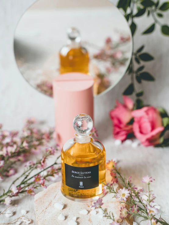 an opened bottle sitting next to a mirror