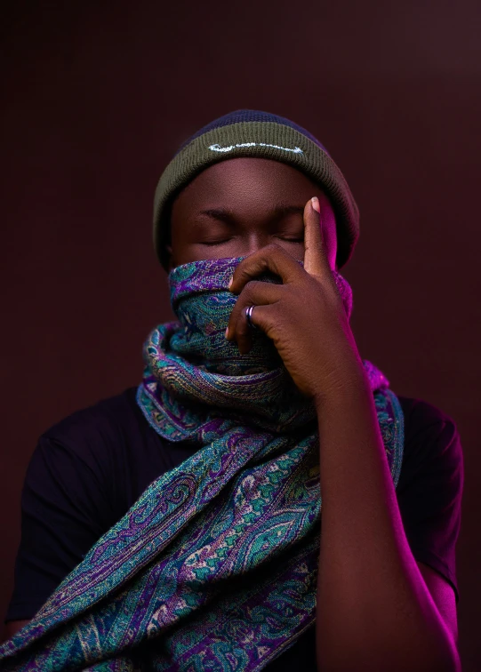 a black woman wearing a multi - colored scarf and hat