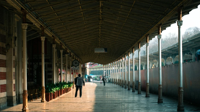 a person walks down an empty walkway between two buildings