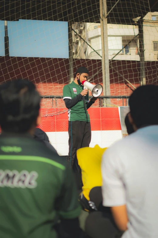 a man holding a white cup while standing next to a crowd