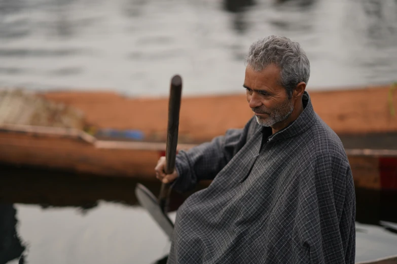 man holding a stick and standing in the water