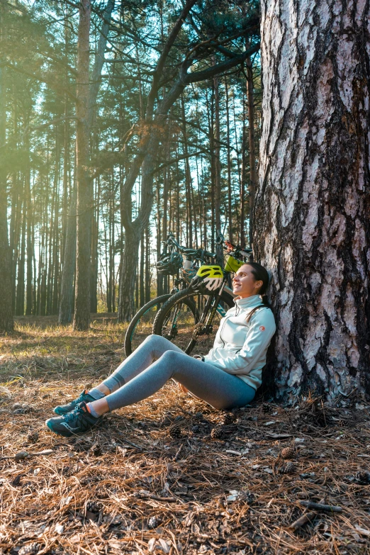  in the woods with her bike resting against a tree