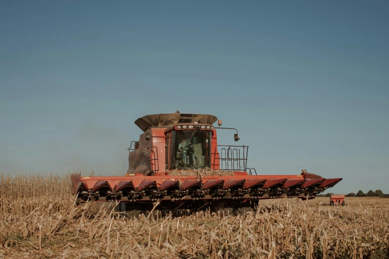 tractor with sprayer cleaning hay in field on sunny day