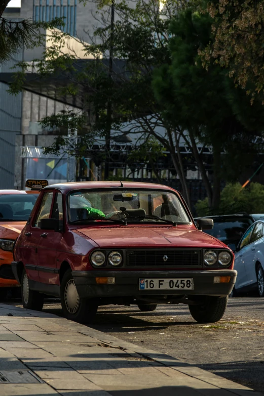 a red car parked on a city side walk