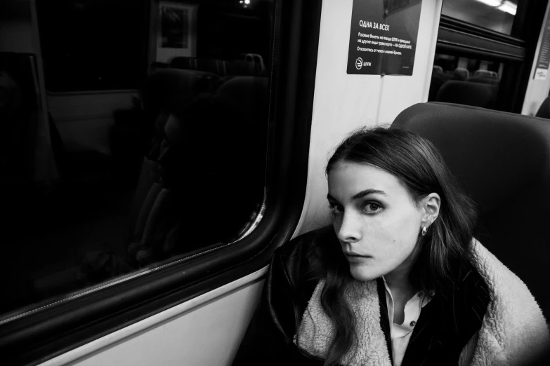 a woman sitting in front of the window of a train