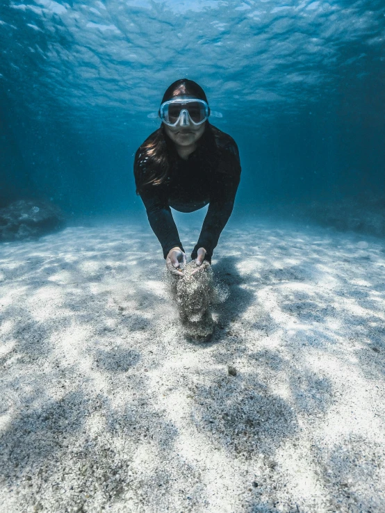 a man with goggles on underwater holding a turtle