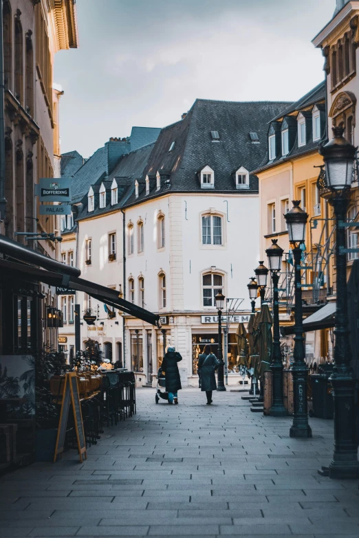 people are walking through an alley way of buildings