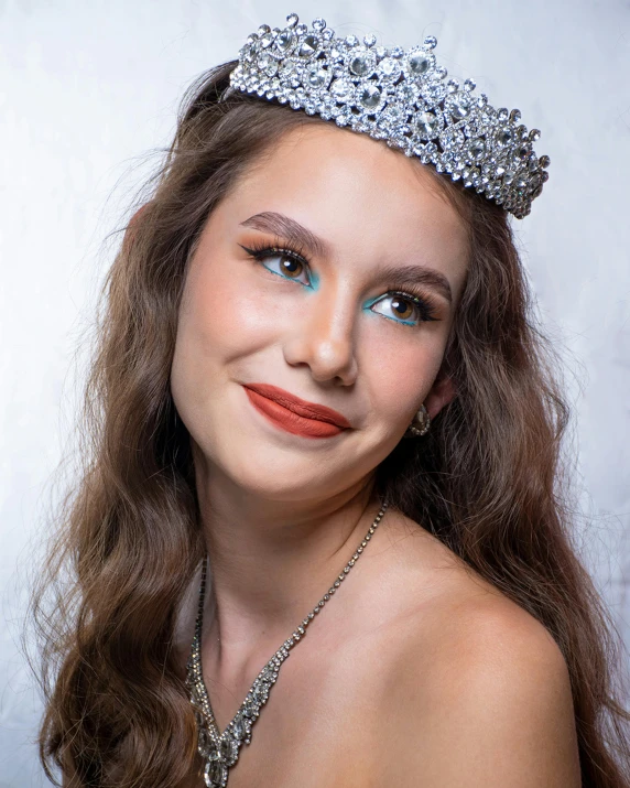 a girl wearing a tiara with a diamond necklace