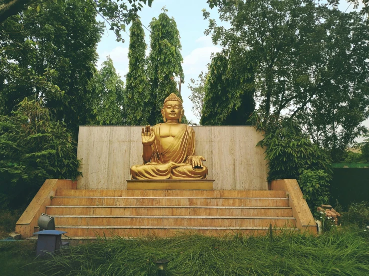 the large buddha statue is beside of a wall