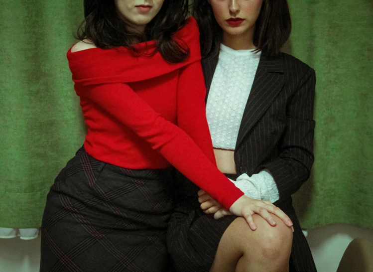 two women standing in front of green curtains