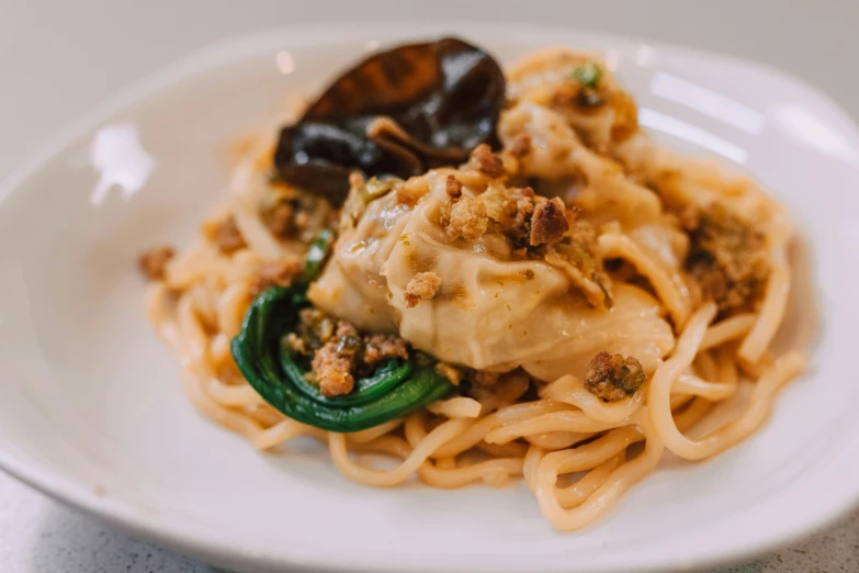 a plate of pasta and vegetables with sauce