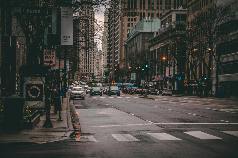 an empty street in a city with cars stopped at a traffic light