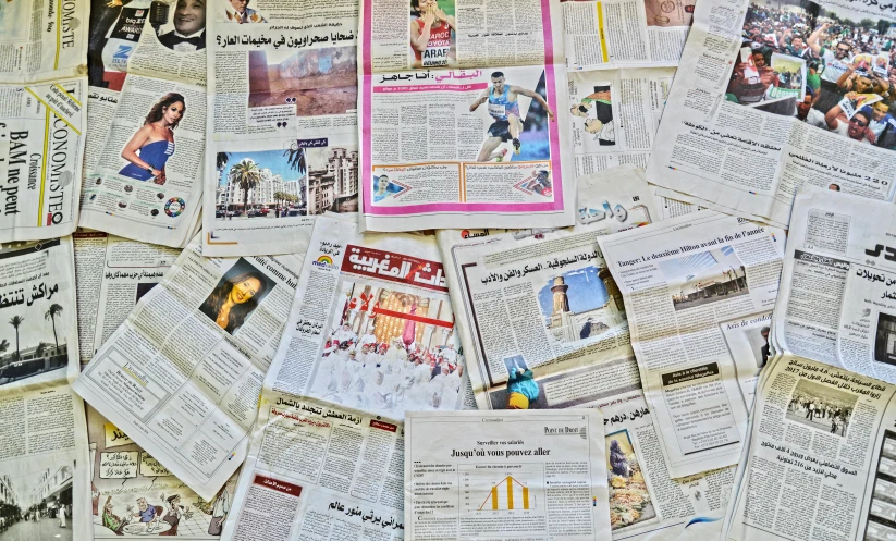 many pieces of newspaper with pictures and other text on them