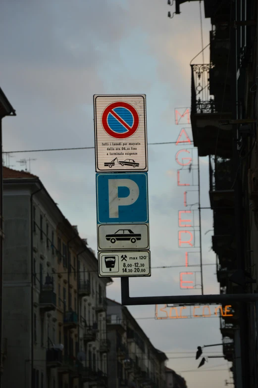 traffic signs on a pole in the middle of the city