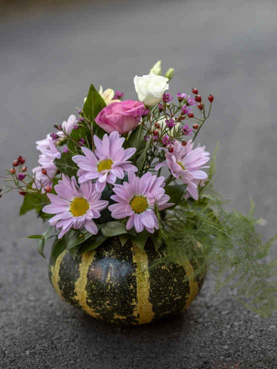 a pot with different flowers and foliage in it