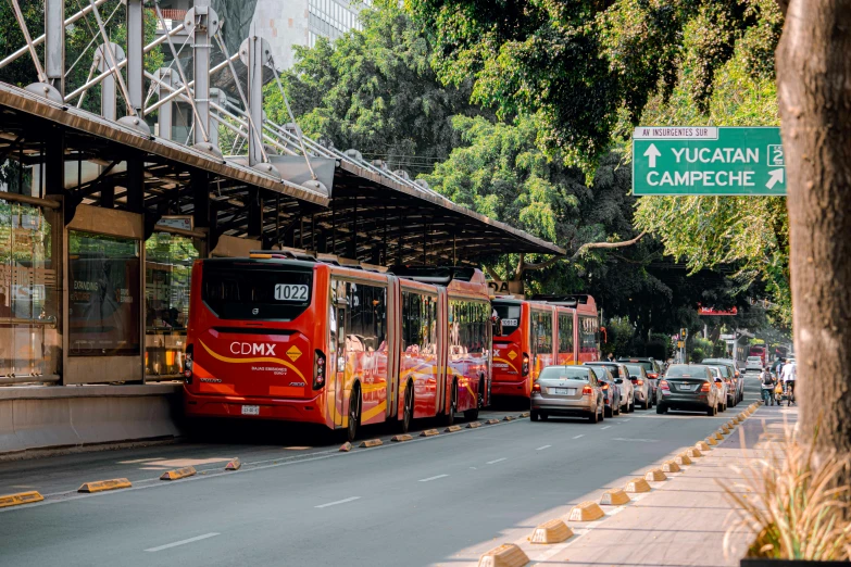 a red bus parked next to a bus stop