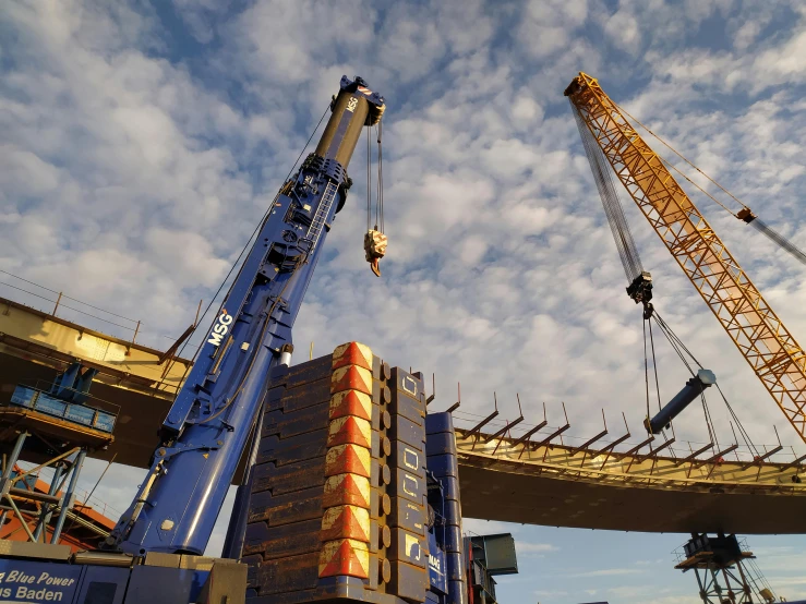 two cranes that are connected to some kind of structure