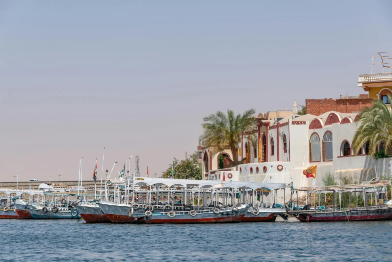 many boats are docked near a building on the shore