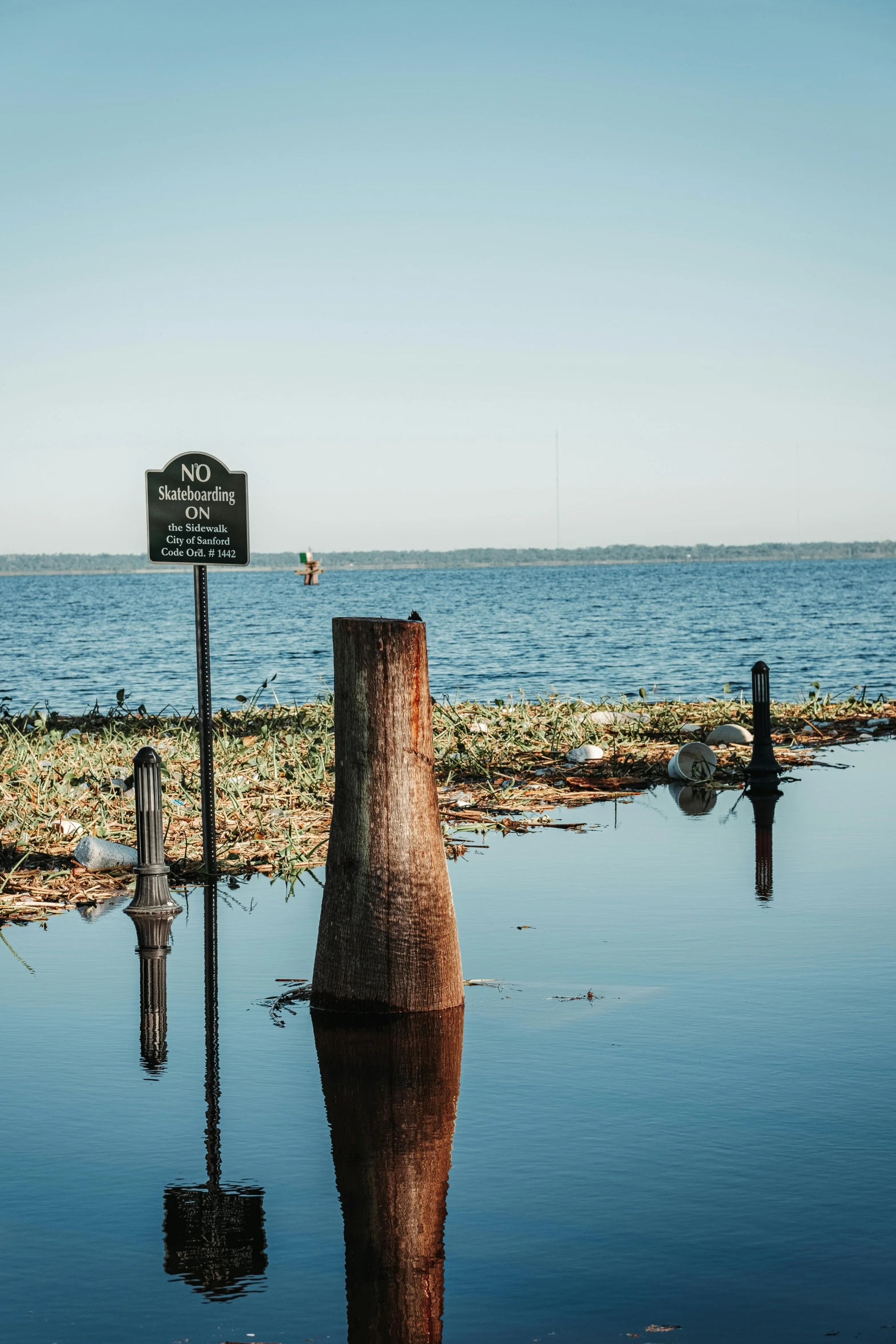 a sign that is on a post near water