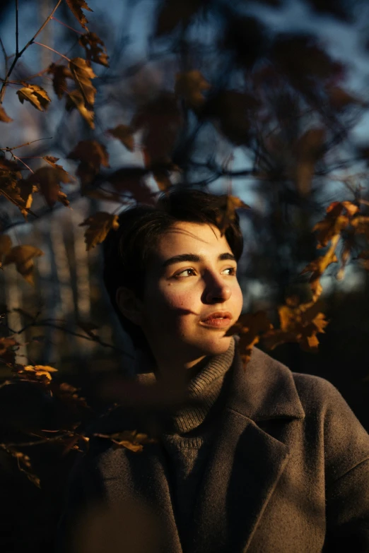 a man sitting down by a tree in the dark