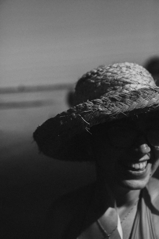 woman smiling wearing a large hat in the desert