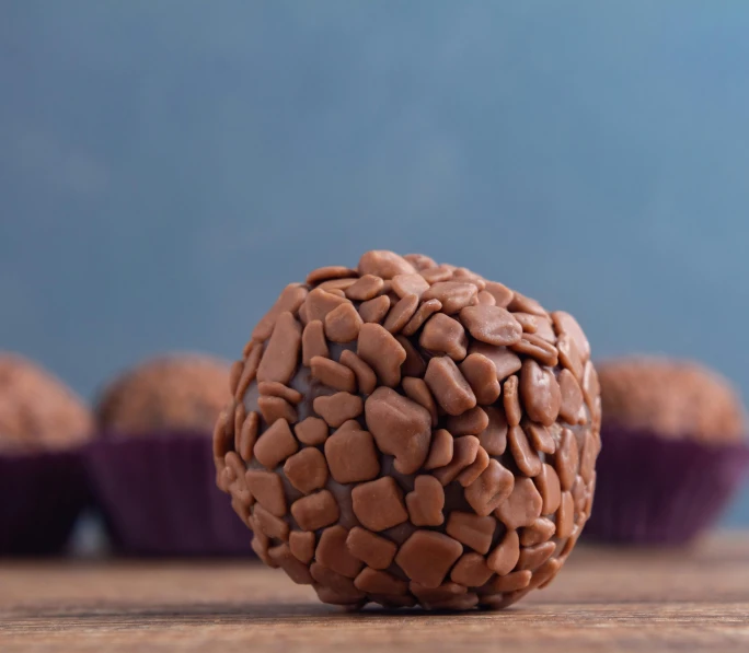 a nutty chocolate ball with another chocolate cupcake behind it