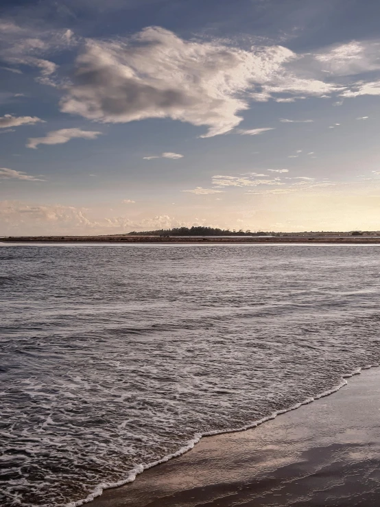 the ocean is near a sandy shore