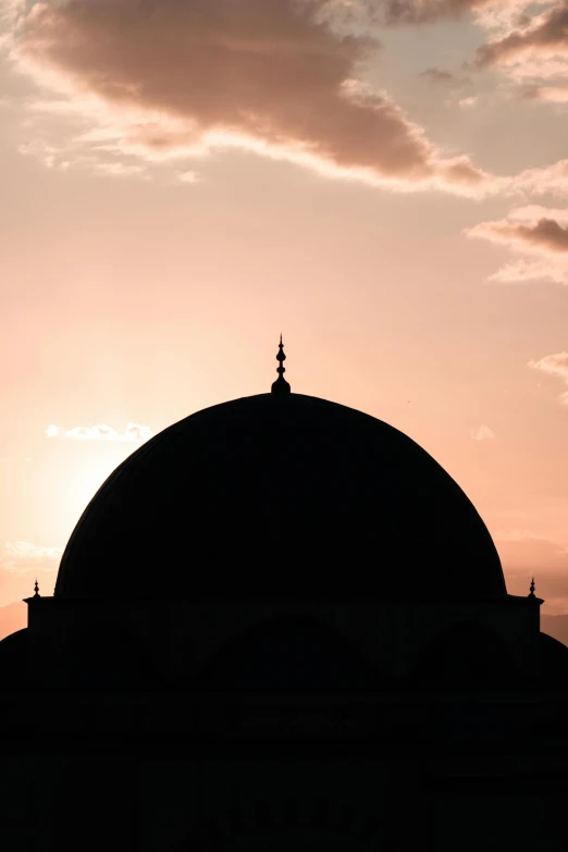 sunset over an ornate islamic structure and sky