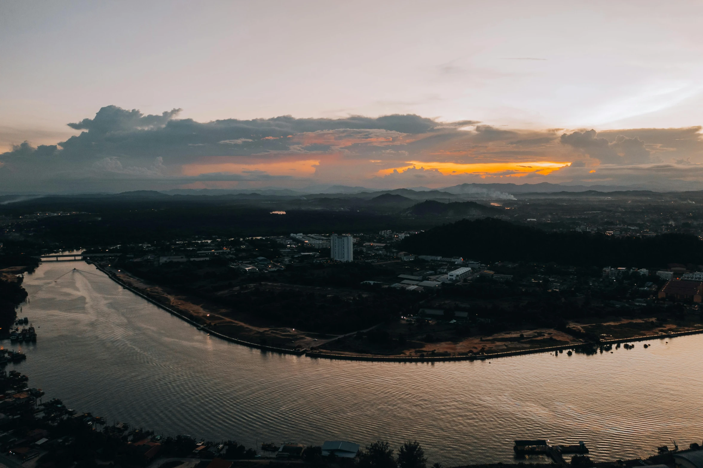 an aerial view of water with the sun behind it