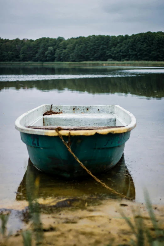 a small rowboat tied to a pier next to the lake