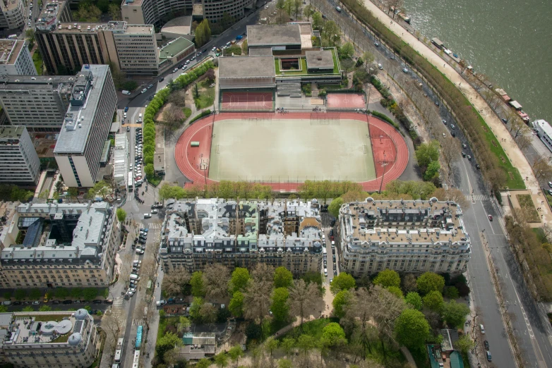 an aerial view of a tennis court next to an asphalted street