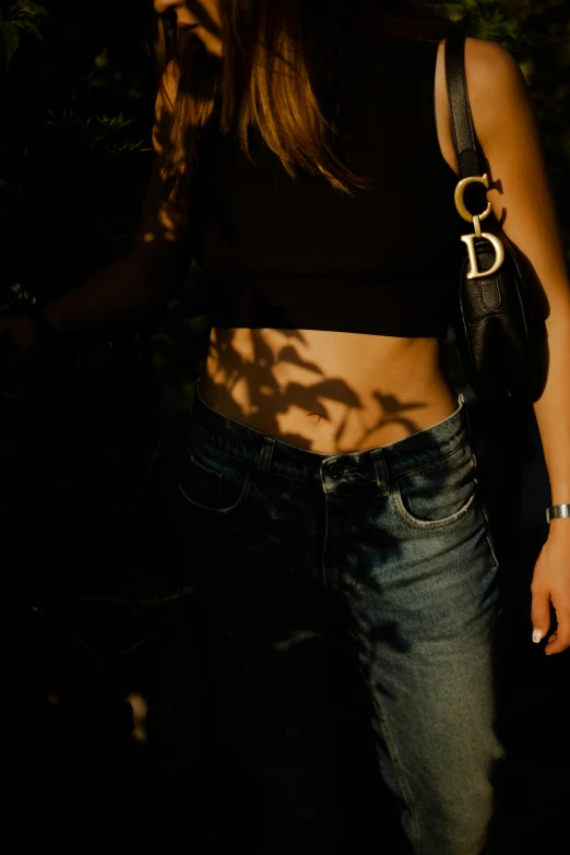 woman wearing black tank top with chain strap in dark forest