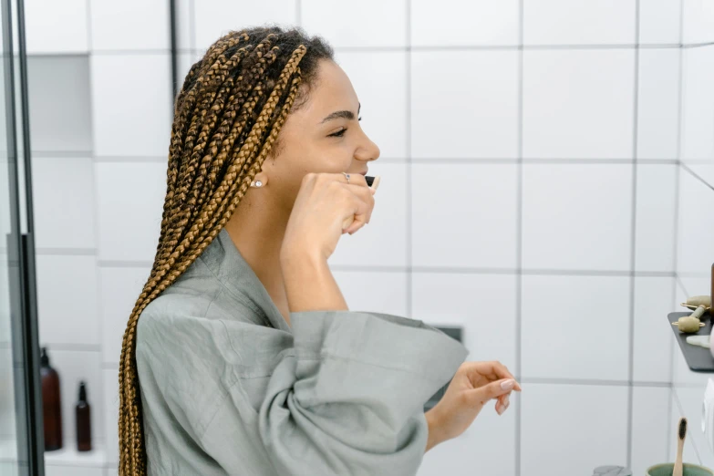 an african woman looking in the mirror with long ids