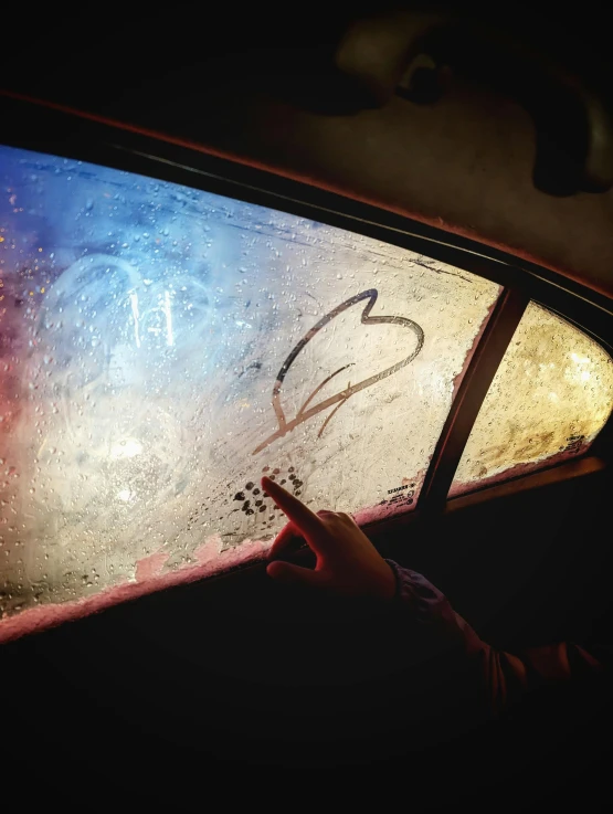 a view of a person driving in the dark from a car