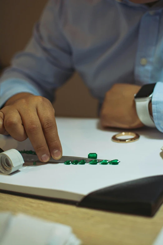 a person holding the edge of an item out with a piece of green paper