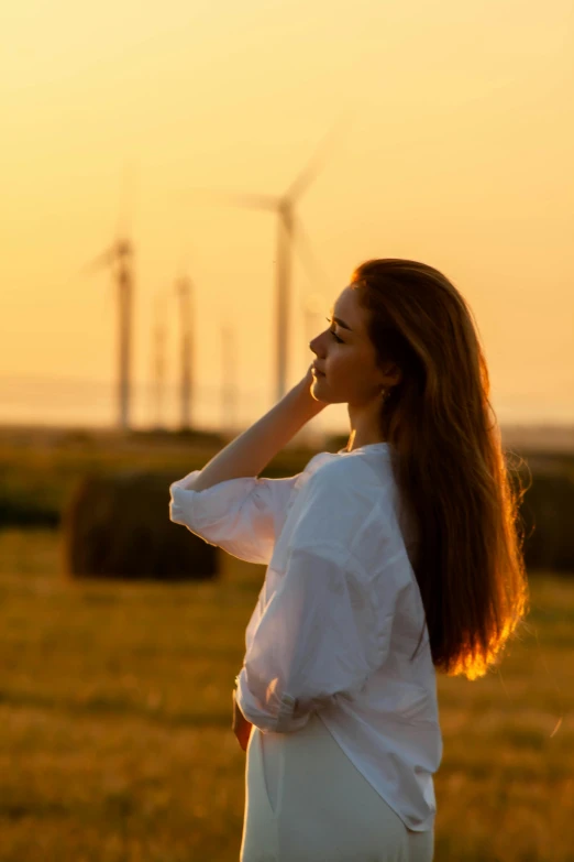 a girl with long hair wearing white standing in the sun