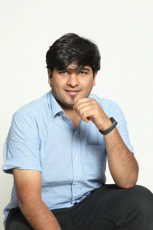 a man in a blue shirt with his arms crossed