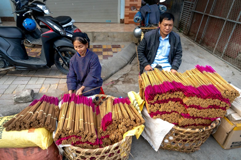 a pair of people working on a street with baskets