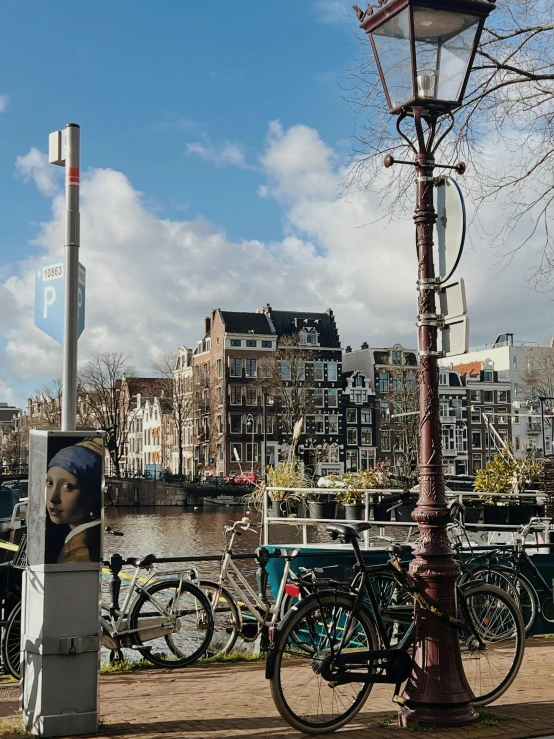 a bike parked next to a lamp post with many bicycles parked on the side of the street