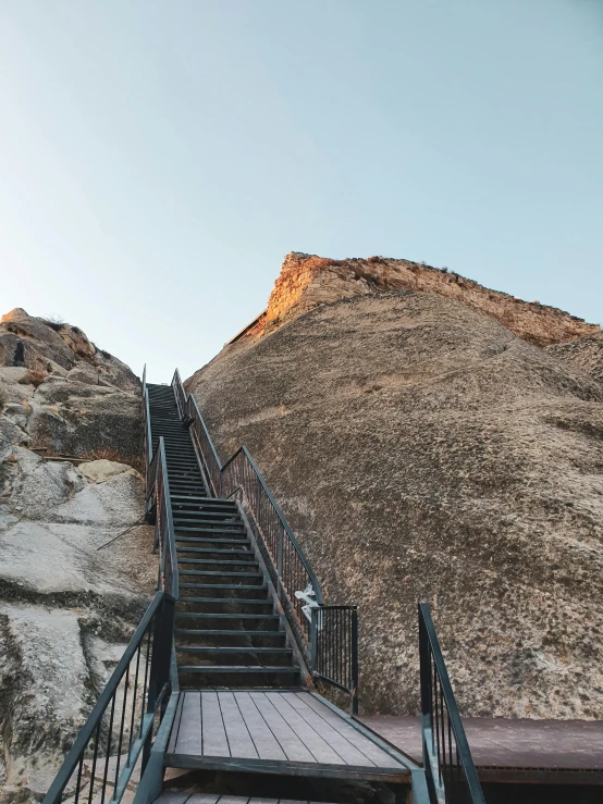 the stairs are going down to the top of a steep hill