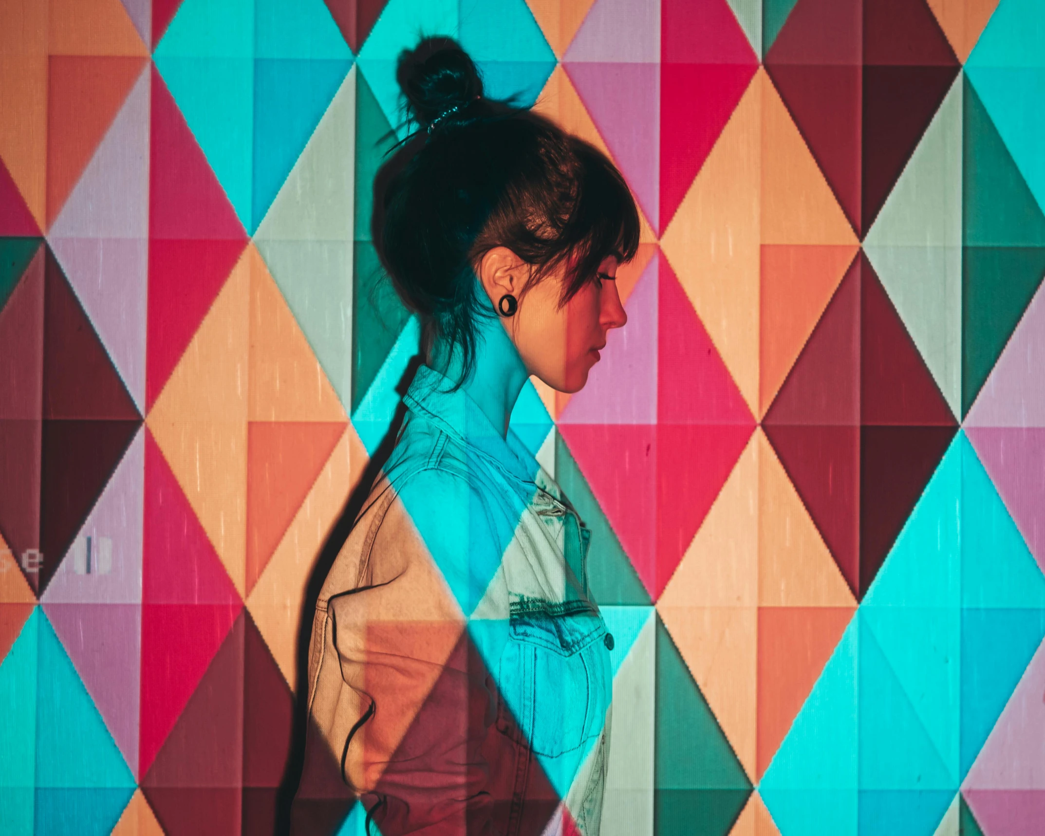 a woman in a blue jacket and multicolored wall