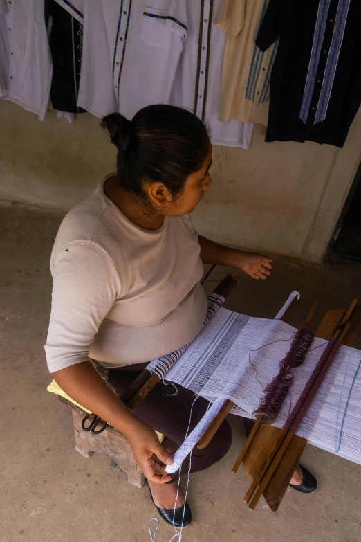 a woman working on an elaborate woven piece