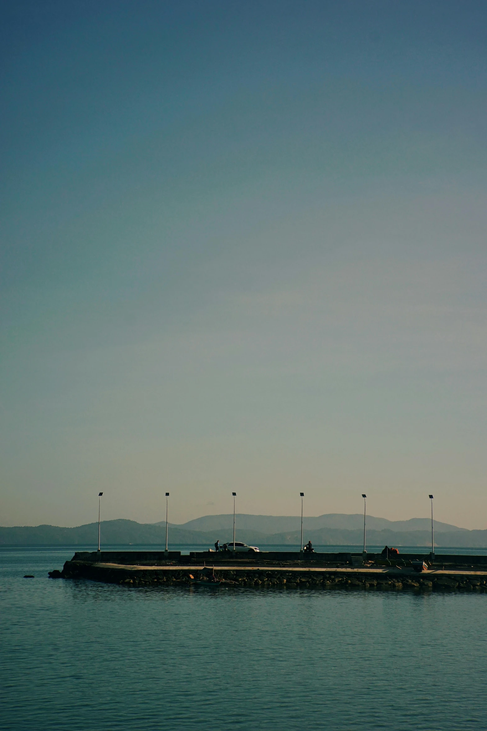 a large body of water with several lights and poles on top