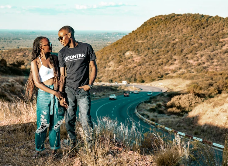 a couple standing on the side of the road posing for a po