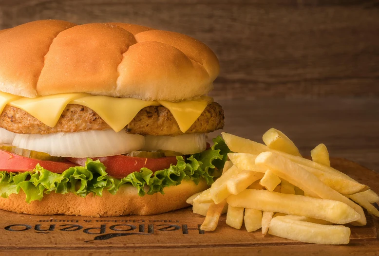 an egg sandwich and fries are on a wooden tray