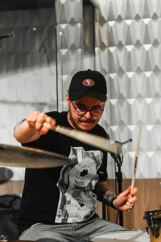 a man with glasses playing a drums set